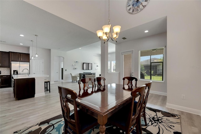 dining room with a notable chandelier and light hardwood / wood-style floors