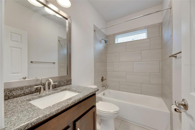 full bathroom featuring tile patterned flooring, vanity, tiled shower / bath combo, and toilet