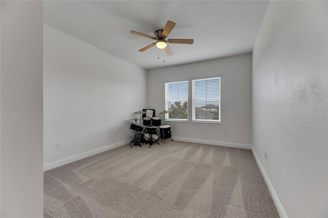 carpeted spare room with ceiling fan