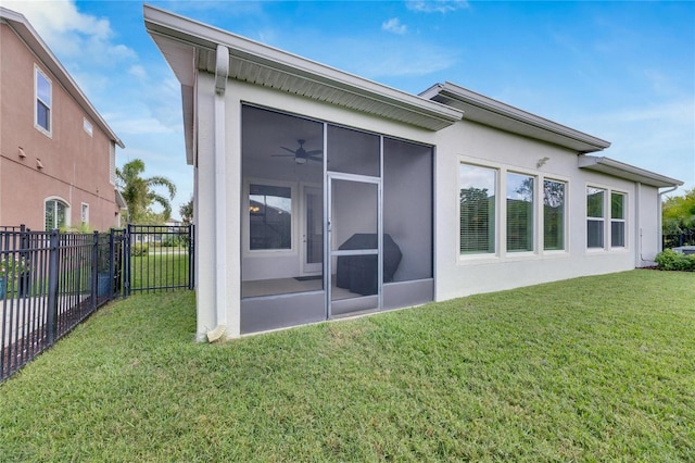 rear view of house featuring a lawn and a sunroom