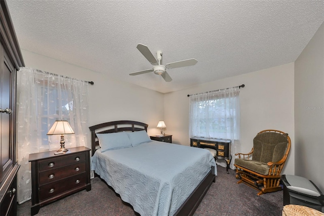 bedroom featuring dark colored carpet, a textured ceiling, and ceiling fan