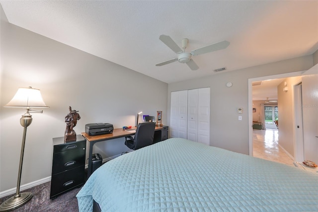 tiled bedroom with ceiling fan and a closet