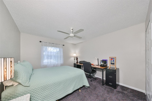 bedroom featuring a textured ceiling, dark carpet, and ceiling fan