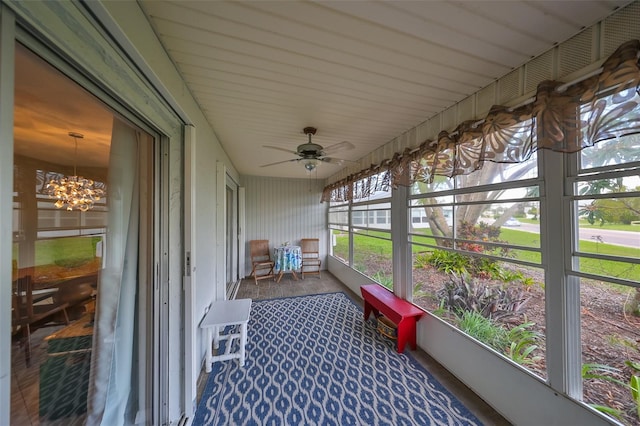 sunroom with ceiling fan with notable chandelier