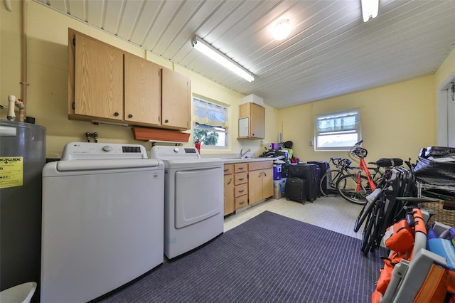 laundry area with light carpet, water heater, cabinets, sink, and independent washer and dryer