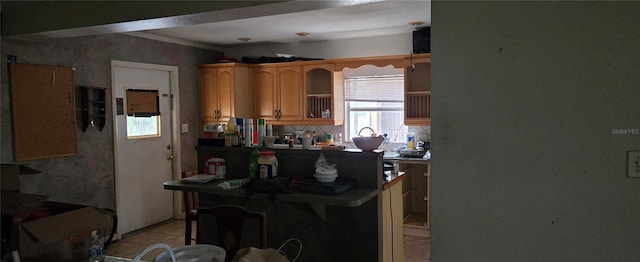 kitchen with a breakfast bar area, light tile patterned floors, and kitchen peninsula