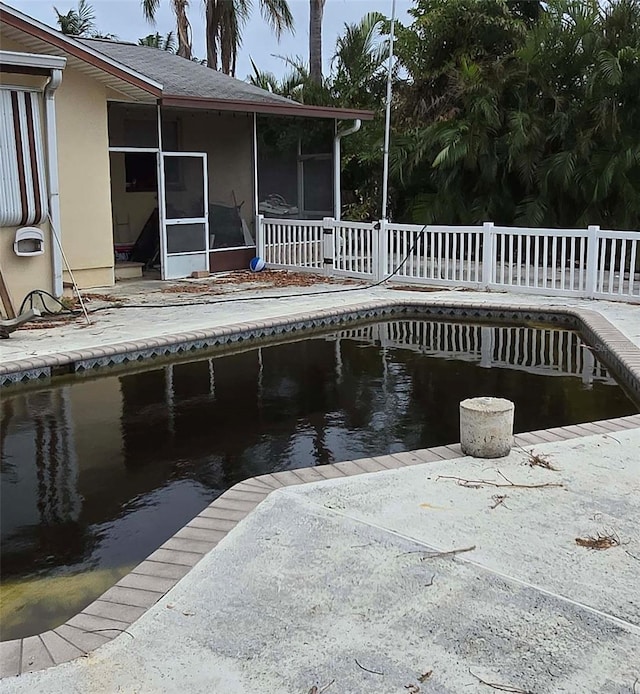 view of swimming pool with a patio area and a sunroom