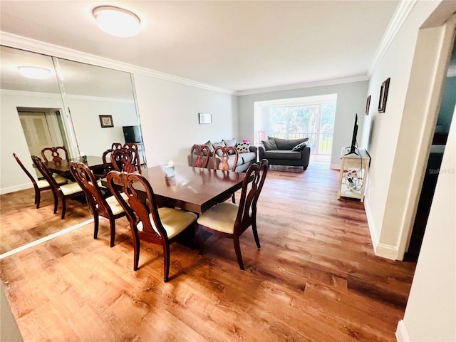 dining area featuring hardwood / wood-style flooring and crown molding