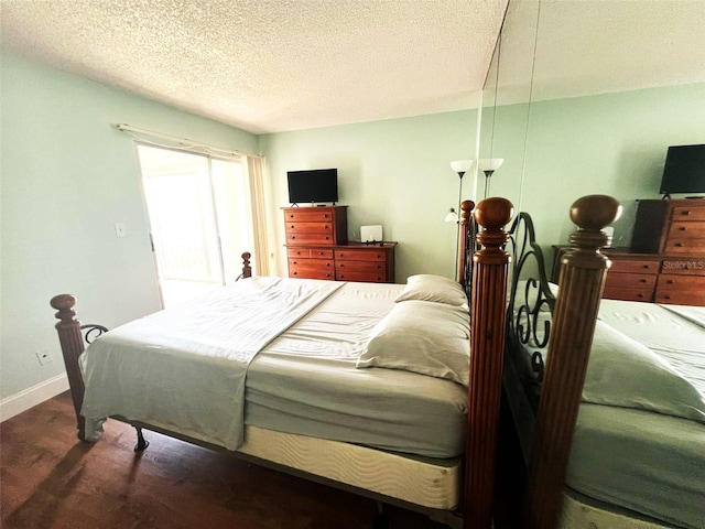 bedroom featuring dark hardwood / wood-style floors and a textured ceiling