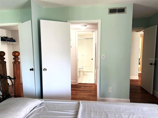 bedroom featuring a closet, a textured ceiling, and hardwood / wood-style flooring