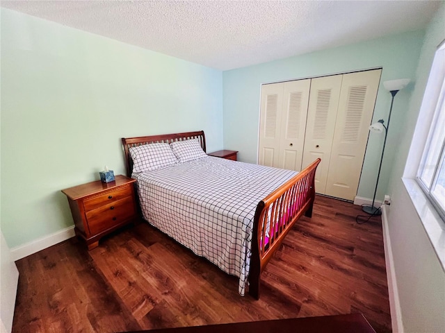 bedroom featuring a textured ceiling, a closet, and dark wood-type flooring