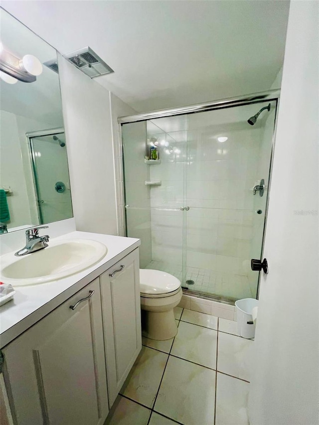 bathroom with walk in shower, tile patterned flooring, vanity, and toilet