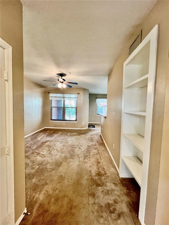 interior space with a textured ceiling and ceiling fan