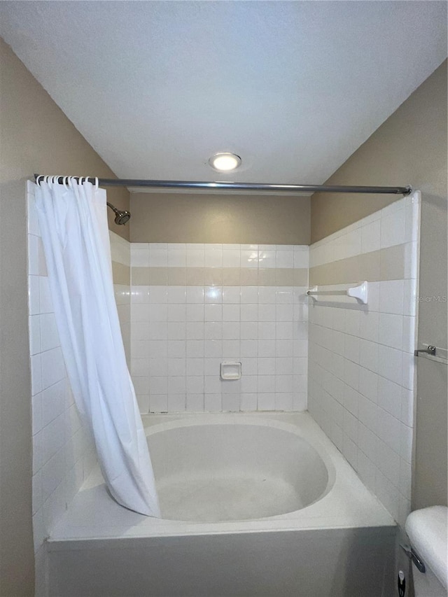 bathroom featuring toilet and shower / bath combo with shower curtain