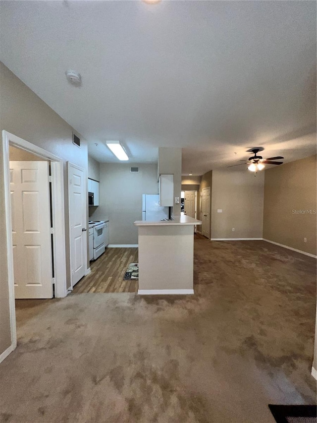 kitchen featuring carpet flooring, white cabinetry, ceiling fan, and white appliances