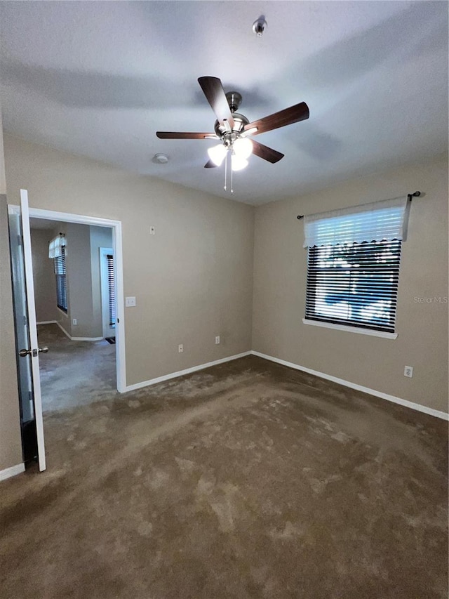 carpeted spare room featuring ceiling fan