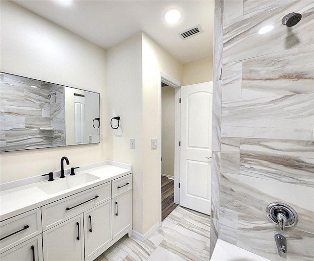 bathroom featuring hardwood / wood-style floors, vanity, and tiled shower / bath