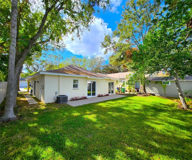 rear view of house with a lawn, a patio, and central AC unit