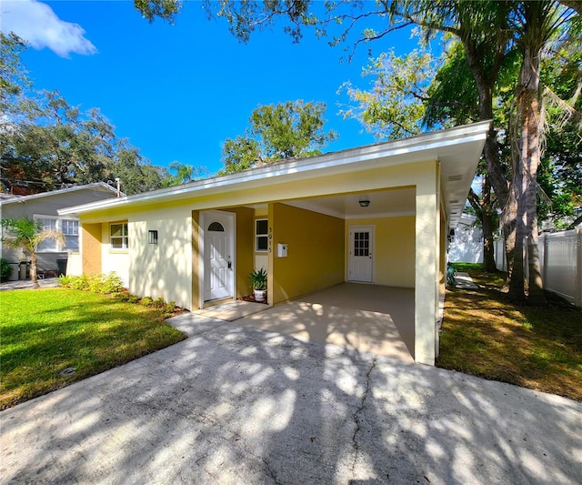 view of front of house with a carport and a front lawn