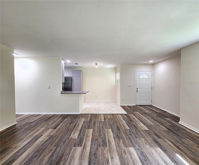 unfurnished living room with dark wood-type flooring