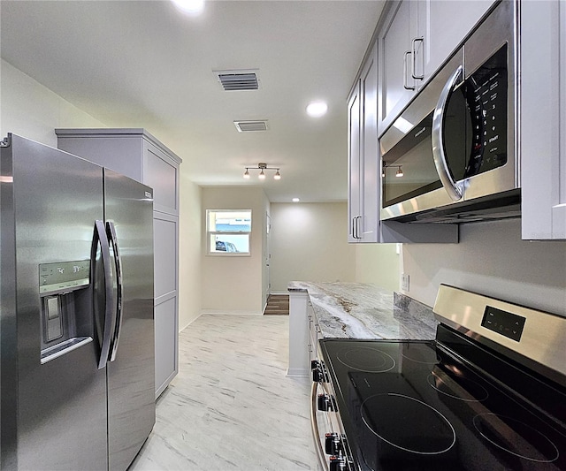 kitchen featuring gray cabinets, light stone counters, and stainless steel appliances