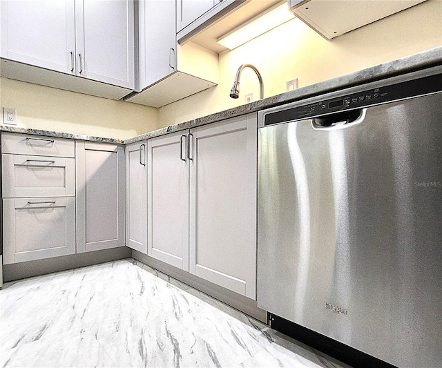 kitchen featuring stainless steel dishwasher and light stone counters