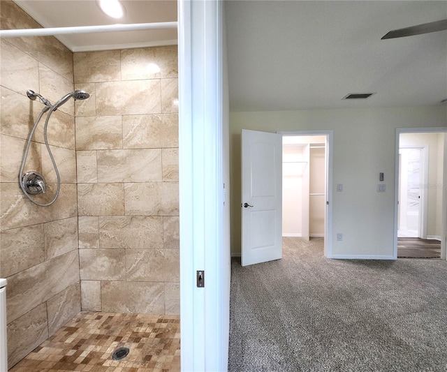 bathroom featuring ceiling fan and tiled shower