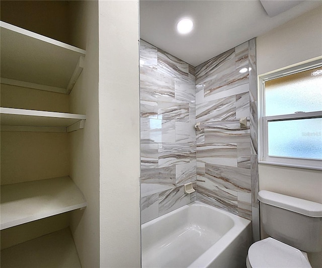 bathroom with tiled shower / bath combo and toilet