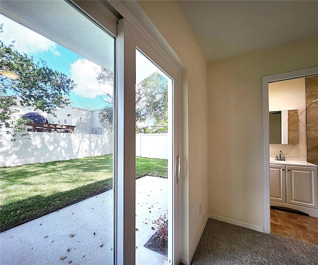 doorway featuring lofted ceiling and sink