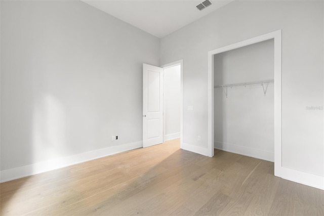 unfurnished bedroom with a closet and light hardwood / wood-style floors