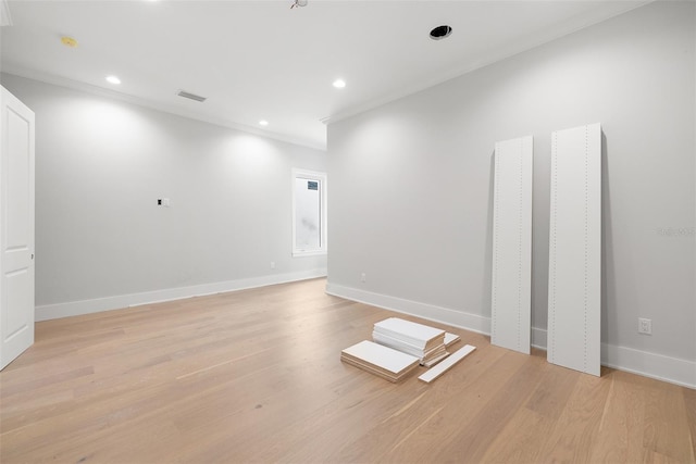 empty room with ornamental molding and light hardwood / wood-style flooring