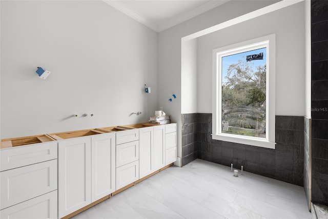 bathroom featuring a wealth of natural light, tile patterned flooring, tile walls, and ornamental molding