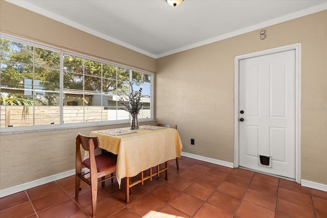 dining room featuring dark tile patterned floors and ornamental molding