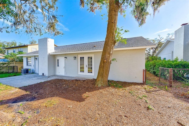 rear view of house with central AC and french doors