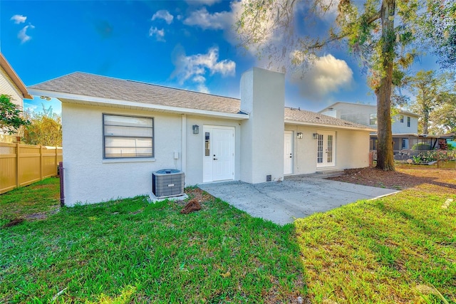 back of house featuring french doors, a patio, central air condition unit, and a lawn