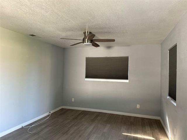 empty room with a textured ceiling, dark hardwood / wood-style floors, and ceiling fan