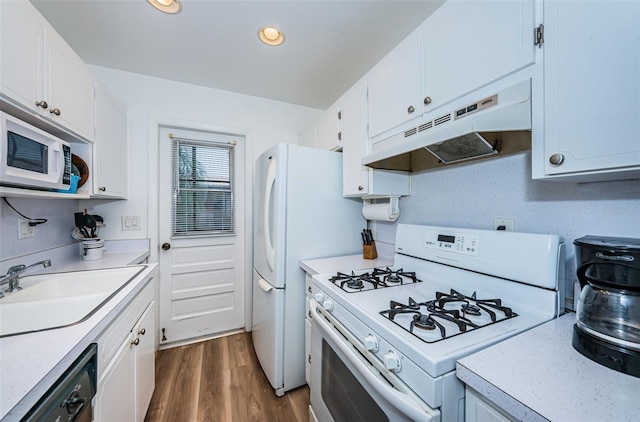 kitchen with white appliances, white cabinetry, and dark hardwood / wood-style flooring