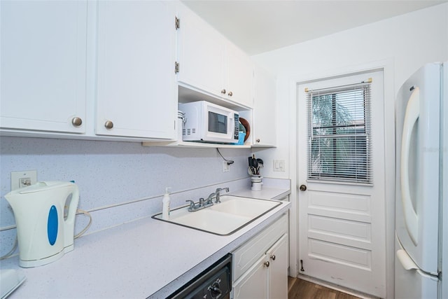 kitchen featuring sink, white cabinets, and white appliances