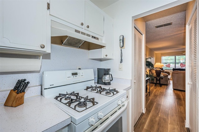 kitchen with decorative backsplash, a textured ceiling, white range with gas cooktop, dark wood-type flooring, and white cabinetry