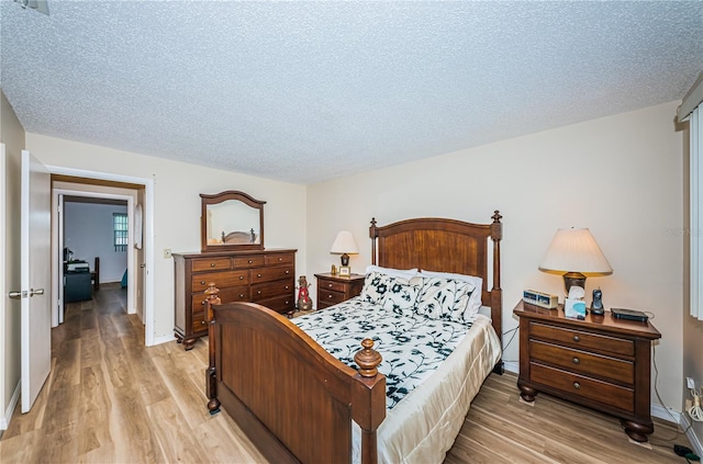 bedroom with light hardwood / wood-style flooring and a textured ceiling