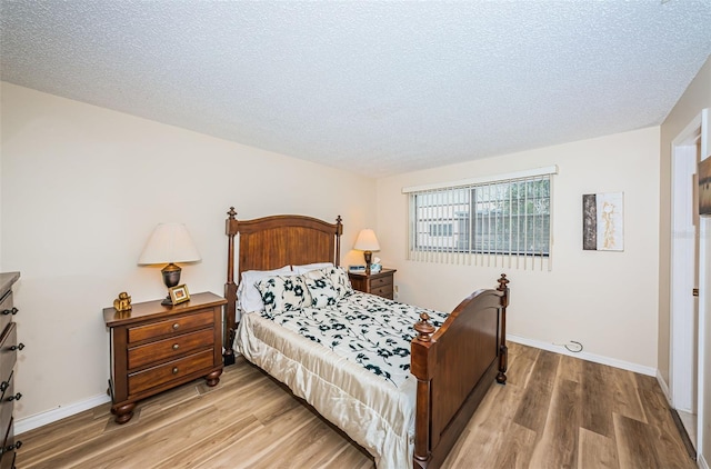 bedroom with hardwood / wood-style floors and a textured ceiling