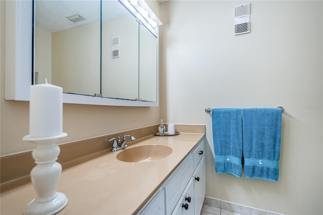 bathroom featuring vanity, a textured ceiling, and tile patterned floors