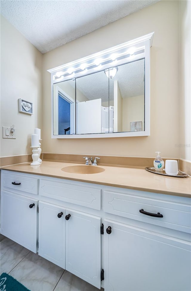 bathroom featuring tile patterned flooring, a textured ceiling, and vanity