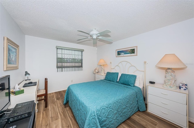 bedroom featuring hardwood / wood-style floors, ceiling fan, and a textured ceiling