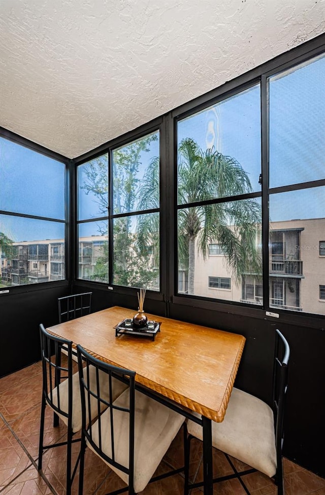 tiled dining area with a textured ceiling