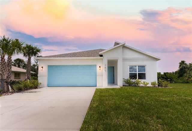 ranch-style home featuring a garage and a yard