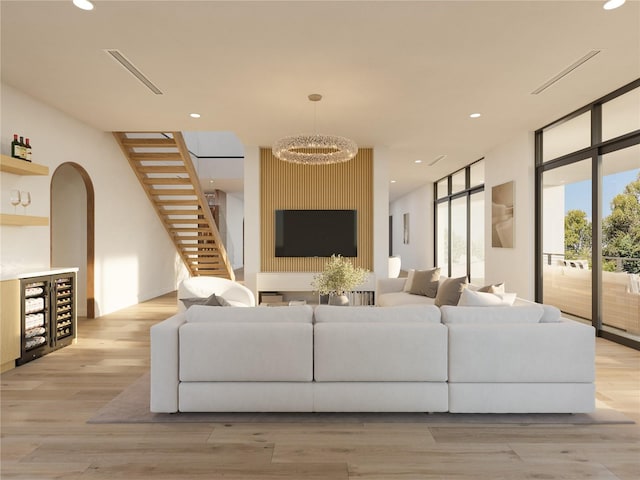 living room with light hardwood / wood-style floors and a notable chandelier