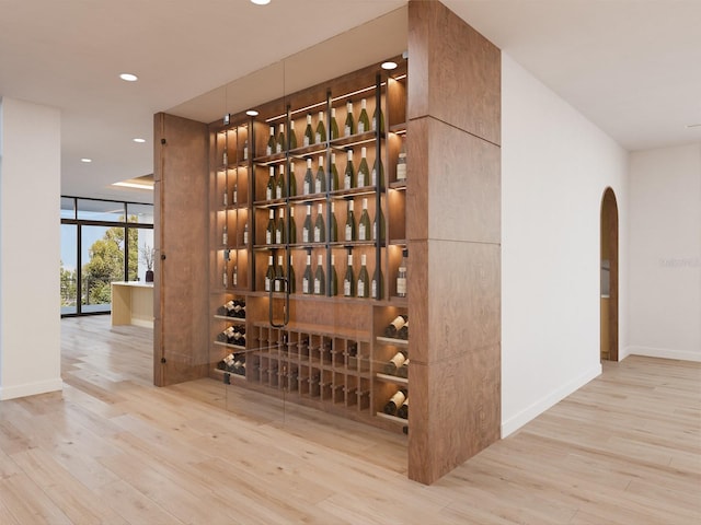 wine room with hardwood / wood-style flooring and expansive windows