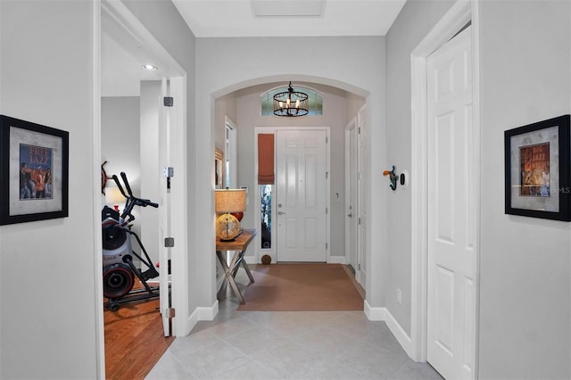 foyer entrance with an inviting chandelier and light tile patterned flooring