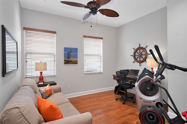 home office with light hardwood / wood-style floors and ceiling fan